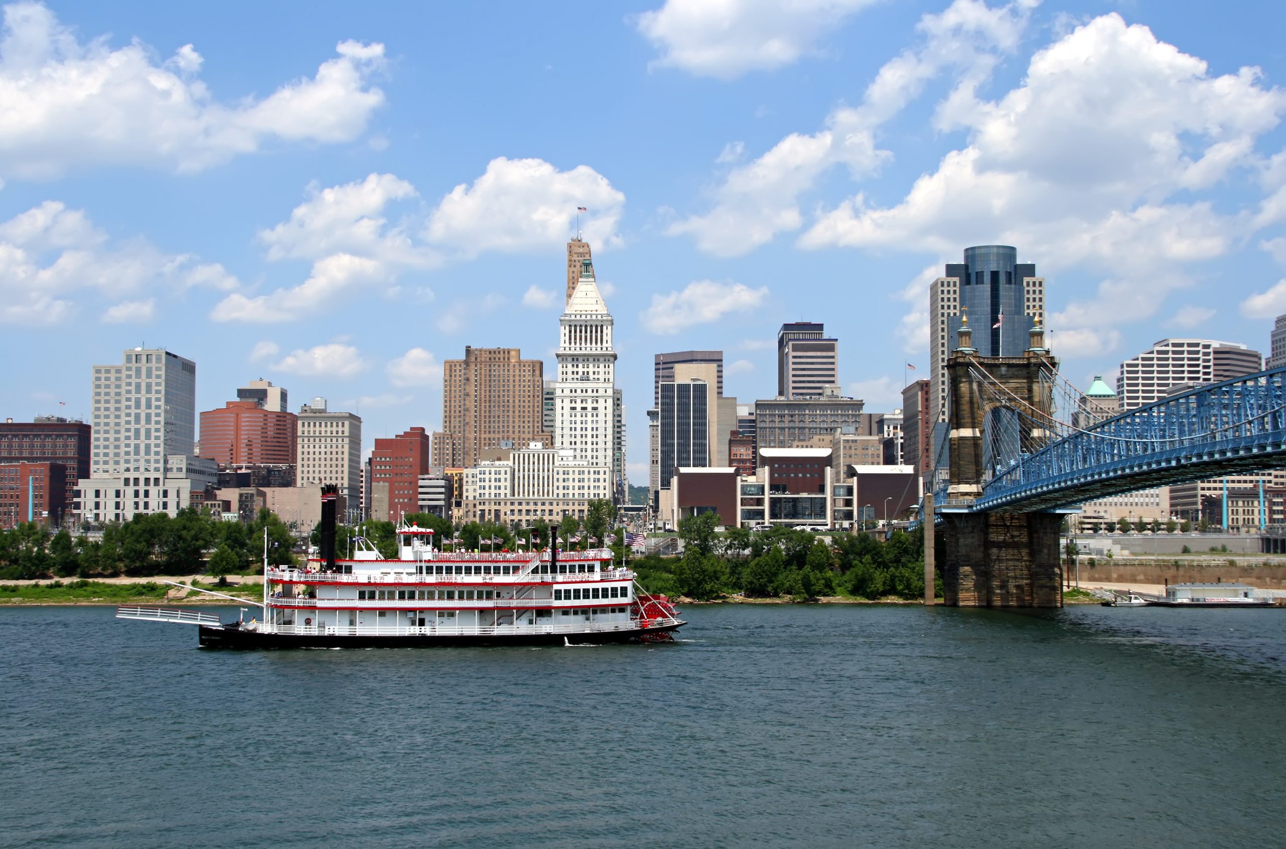 Replica steamboat travels down the Ohio River in front of the Cincinnati skyline.